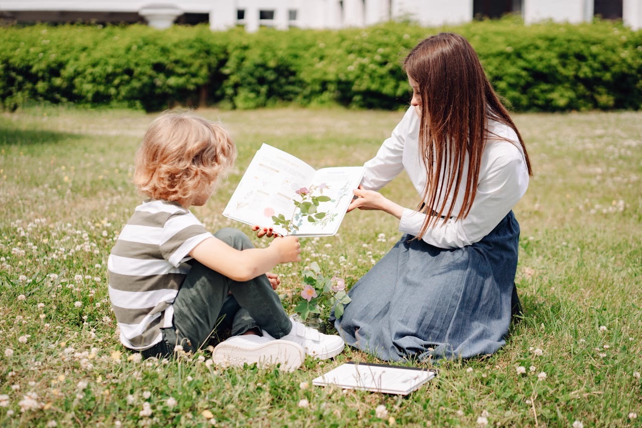 Tutor reading with a student outdoors during a summer tutoring session in Greenwich, CT to prevent summer learning loss