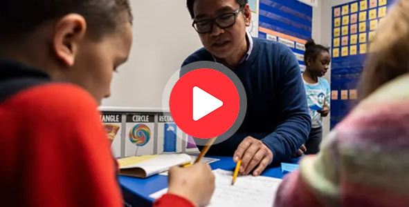 Teacher assisting students in classroom.